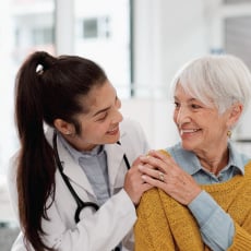 A doctor checks in with an elderly woman